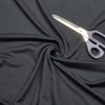 Käärid mustal kangal voltidega