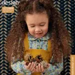 Tüdruk sügisrõivastes hoiab käbisid.