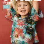 Naeratav laps suvises mustrilises särgis ja kübaraga