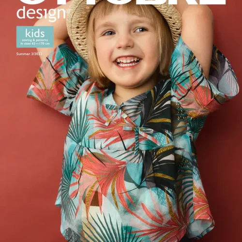 Naeratav laps suvises mustrilises särgis ja kübaraga