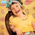 Naeratav laps lillelises suverõivas ajakirja kaanel