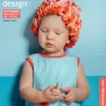 Laps sinises kleidis ja oranžis mütsis