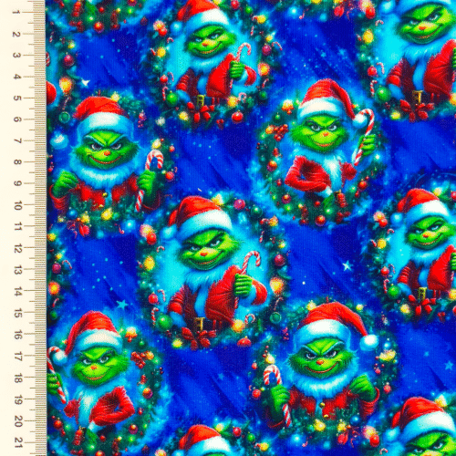 Jõulukangas rohelise tegelase ja kommikepiga muster