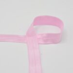 Heleroosa elastne lint valgel taustal