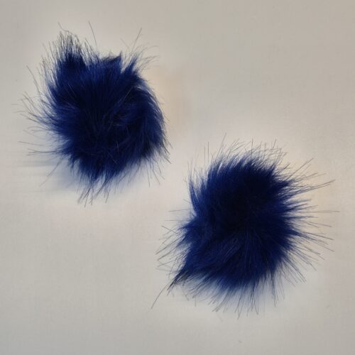 Kaks sinist karvast pom-pomi valgel taustal