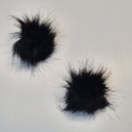 Kaks musta karvast pompooni valgel taustal