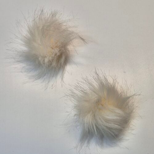 Kaks valget karvast pom-pom palli valgel taustal