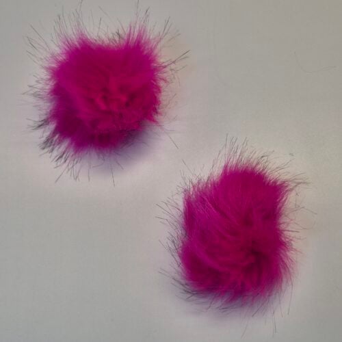 Kaks roosat karvast pom-pomi valgel taustal