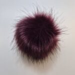 Tumepunane karvane võtmehoidja valgel taustal