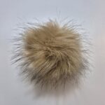 Helepruun karvane pompon valgel taustal