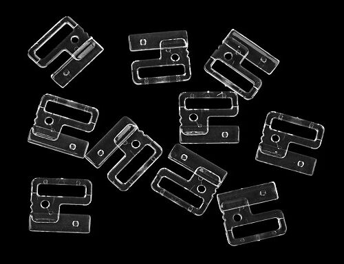 Läbipaistvad plastklambrid mustal taustal