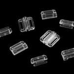 Läbipaistvad plastist rihmaregulaatorid mustal taustal