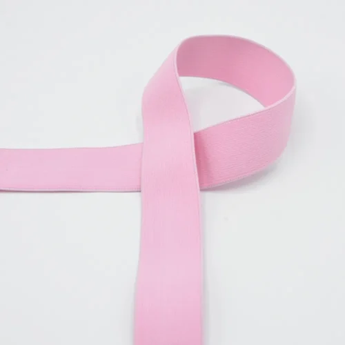 Heleroosa elastne lint valgel taustal