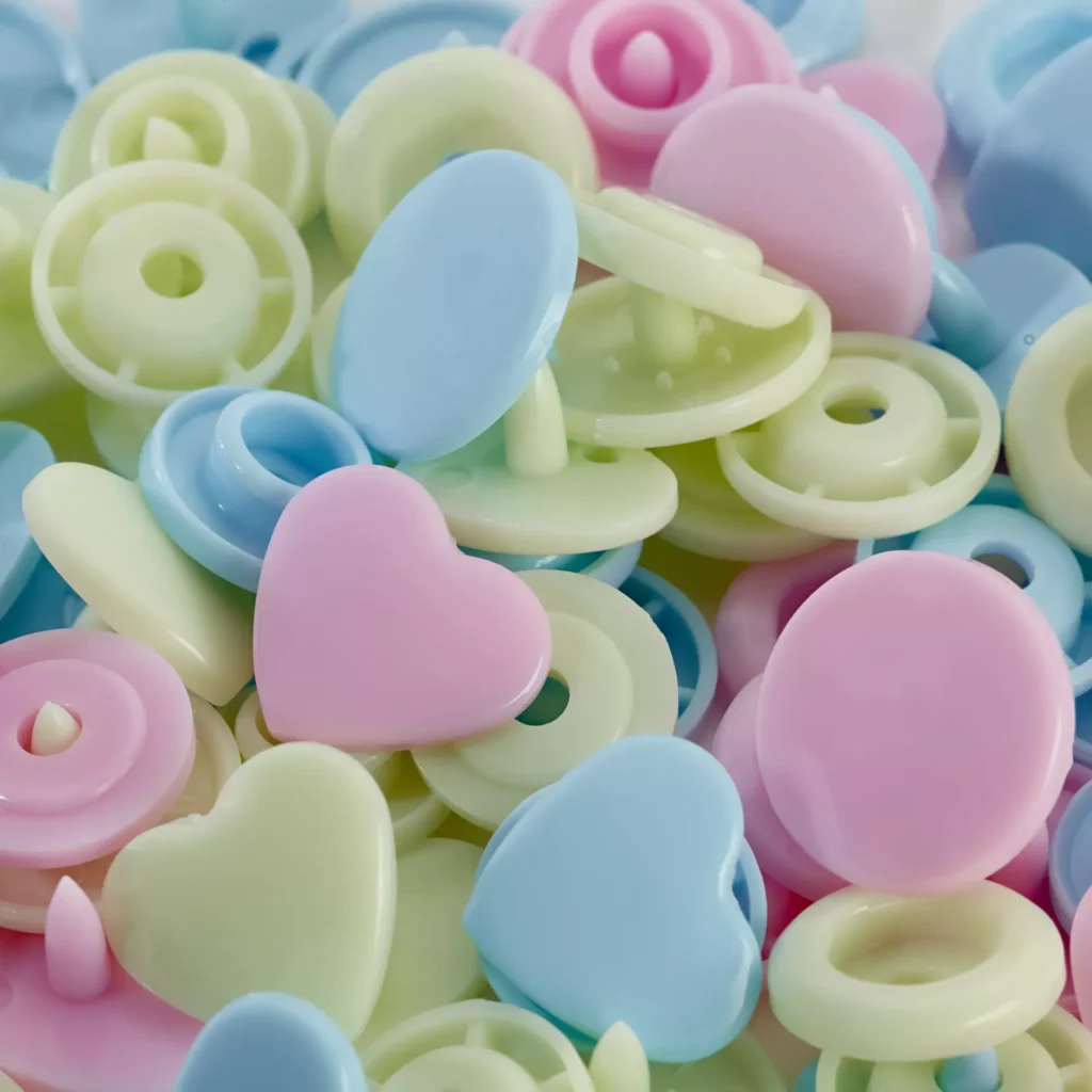 Pastelsed südamekujulised ja ümmargused plastnööbid