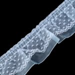 Valge pitsiline kangas mustal taustal