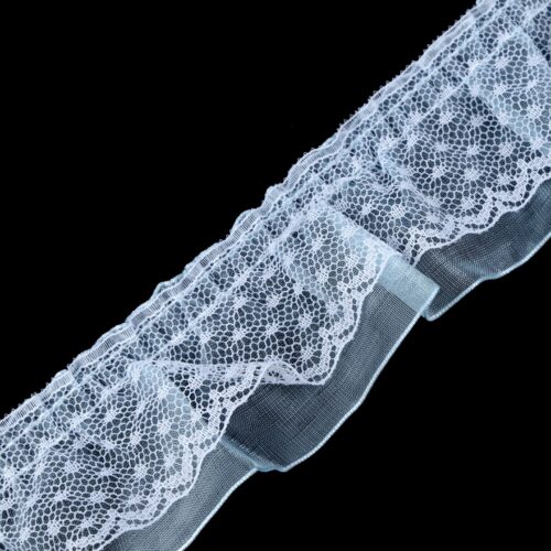 Valge pitsiline kangas mustal taustal