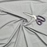 Purple scissors on twisted gray fabric