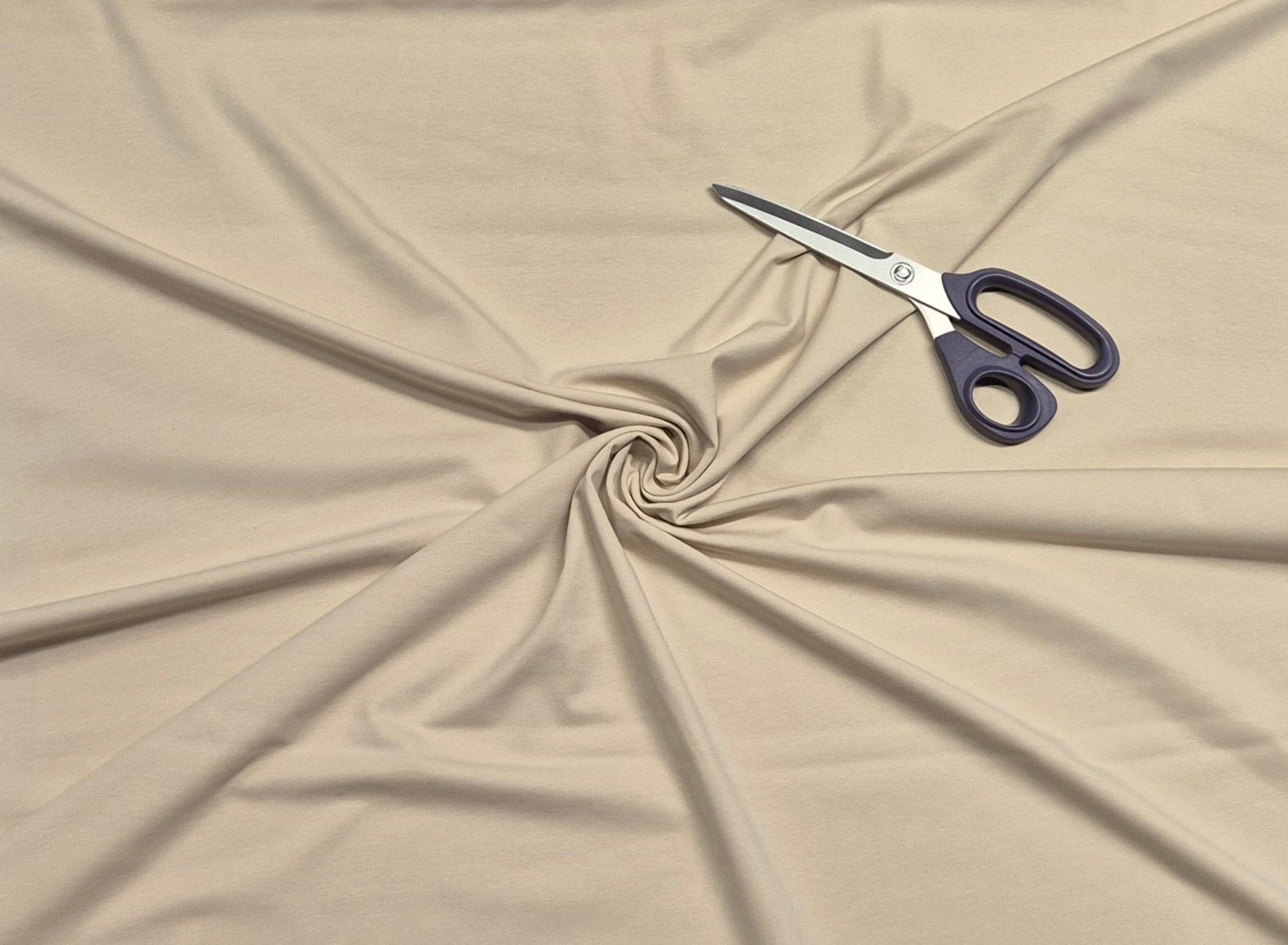 Beige fabric swirl with scissors on top