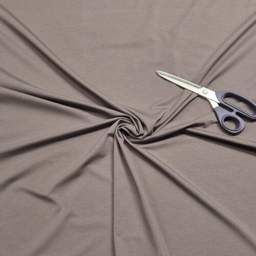 Scissors on twisted brown fabric background