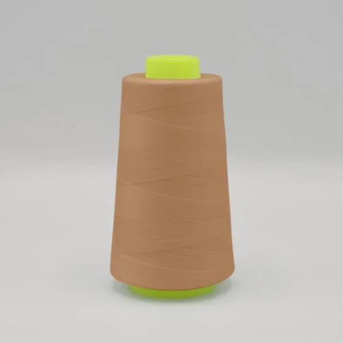 Cone of tan sewing thread on white background