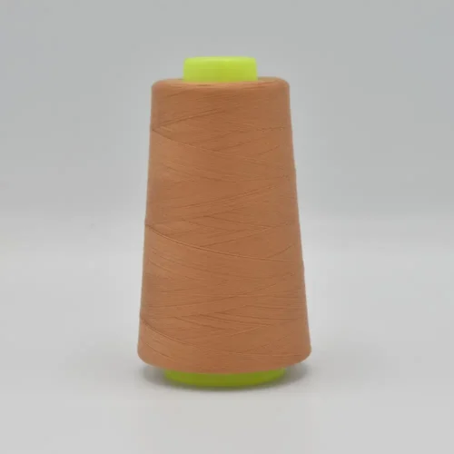 Peach thread spool on green plastic cone
